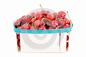 Red cherries in wooden basket on white background