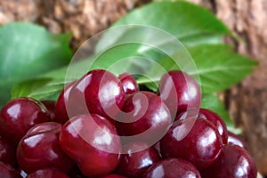 Red cherry by close-up, on wood background