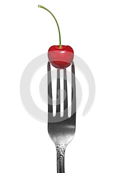 Red cherry on fork isolated on white