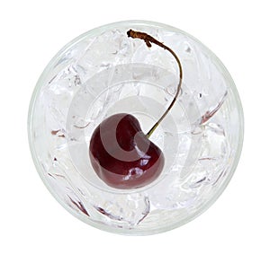 Red cherry on ice cubes in a glass top view isolated on white ba