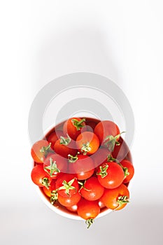 Red cherry tomato in  ceramic bowl on white background