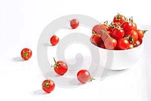 Red cherry tomato in  ceramic bowl on white background