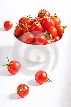 Red cherry tomato in  ceramic bowl on white background