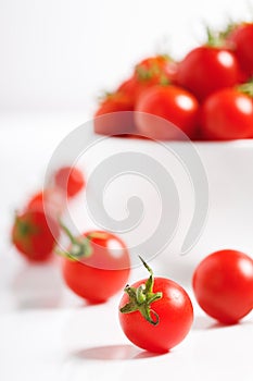 Red cherry tomato in  ceramic bowl on white background