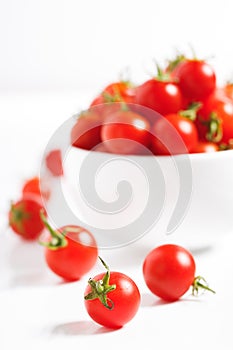Red cherry tomato in  ceramic bowl on white background