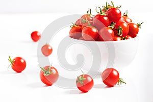 Red cherry tomato in  ceramic bowl on white background