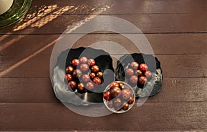 red cherry tomatoes of different types on black plates