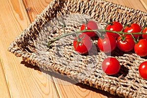 Red cherry vine sun-ripened piccolo tomatoes in wicker basket tr