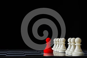 Red chess standing out from white chess on chess board and black background. Leadership concept