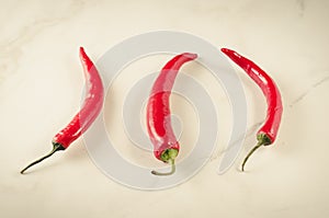 red Chile on white stone background/shining red hot pepper on a white background. Top view