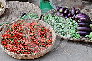 Red chili pepper eggplants and other vegetables sold in a Cambodian food street market