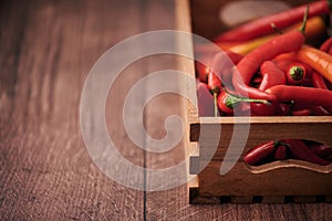 Red chili peppers in a box put on a wooden surface