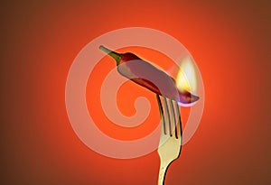 Red chili peppers on a fork with fire on a gradient background