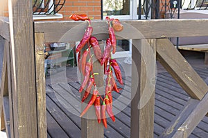 red chili peppers hanging on ukrainian porch and drying