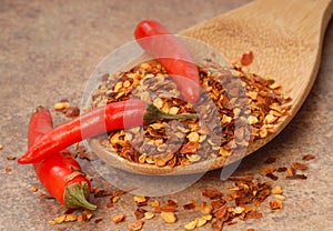 Red chili peppers and red pepper flakes on a spoon