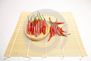 Red chili peppers in wooden bowl on white background