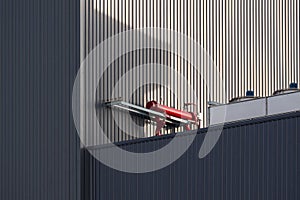 Red chiller with compressors of air conditioners system on top of black modern industrial building