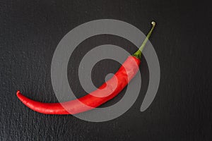 A red chilli pepper against a black background