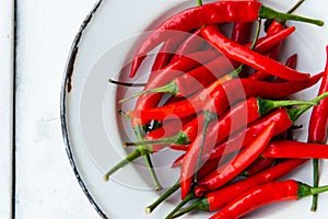 Red chilli pepper in old plate on white table