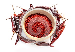 Red Chilli pepper seedless flakes in wooden bowl and Dried red chili pepper on white background.