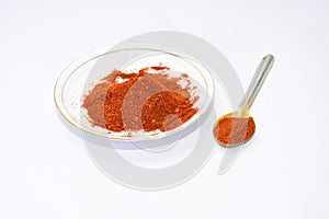 Red chilli powder in white plate with spoon. photo