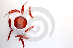 Red chillies with red chilly powder on white background