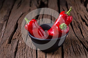 Red chilly pepper on wooden black background. Red hot chili peppers.