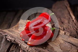 Red chilly pepper on wooden black background. Red hot chili peppers.