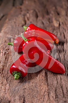 Red chilly pepper on wooden black background. Red hot chili peppers.