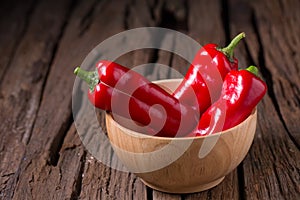 Red chilly pepper on wooden black background. Red hot chili peppers.
