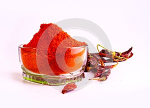 Red chilly peppers and powder of dried chilies in a bowl isolated in the light background