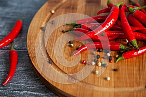 Red chilly peppers on a round wooden board