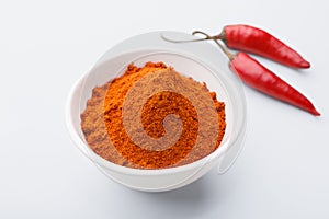 Red chilly powder in bowl over white background