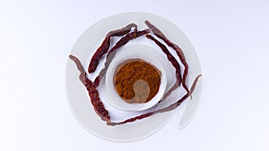 Red Chilly Powder in a bowl on white background.Selective focus and crop fragment.
