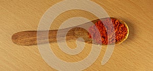 red chilly powder wooden spoon on wooden background