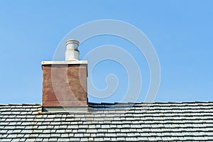 red chimney with metal vent and gray roof