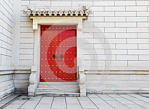 Red Chinese door with locked key and bronze lion head knob on co