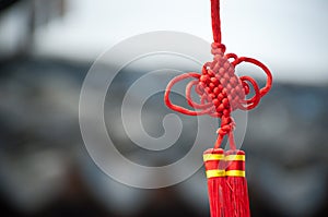 A red Chinese knot decoration hanging in a Suzhou street