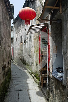 A red Chinese lantern hangs outside a small alley shop in Hongcun, China