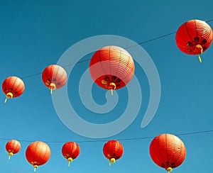 Red Chinese paper lanterns against blue sky