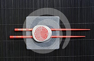 Red chopsticks on black bamboo
