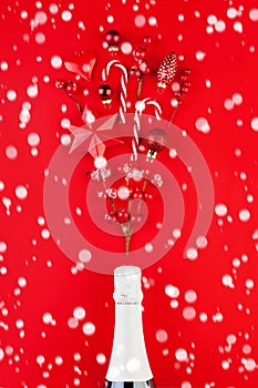 Red Christmas background with white snow, sparkling wine bottle