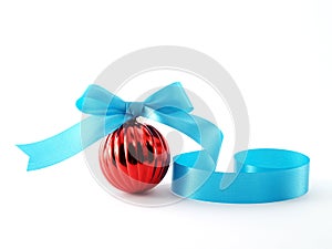 red shiny christmas ball with spiral light blue ribbon bow isolated on white background