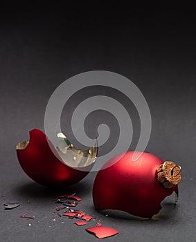 Red Christmas ball broken, dark gray background, closeup view