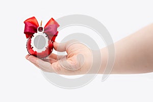 Red Christmas ball isolated on white background in a female hand. Place for photography