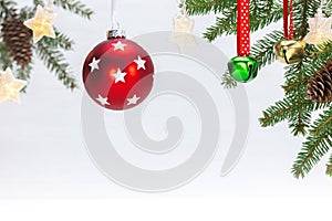 Red christmas ball, jingle bell, fir tree branch, glowing star garland lights