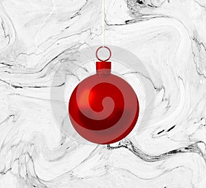 Red christmas ball ornament hanging on marble white background. Holiday concept, new year.