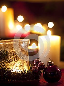 Red christmas ball ornaments with burning candles (shallow depth