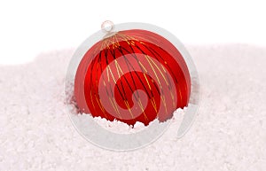 Red christmas ball in snow.
