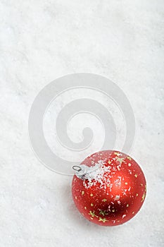 Red christmas ball on snowy background